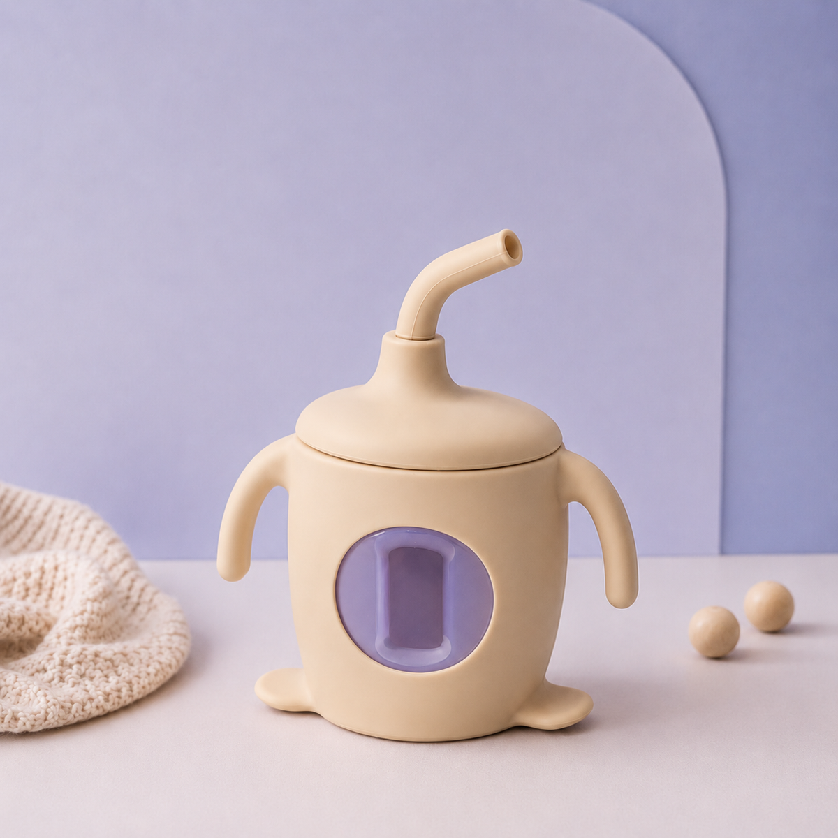 Beige baby sippy cup with purple interior on a light blue background