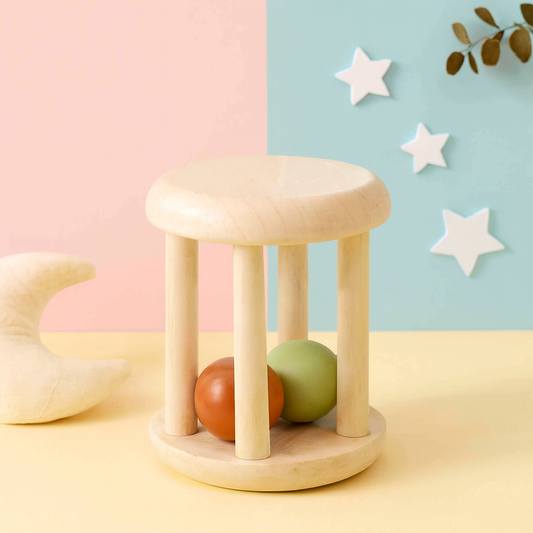 Wooden rolling tower toy with two colorful balls inside on pastel background.