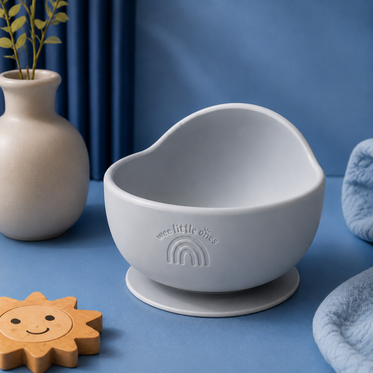 Gray bowl with suction cup on a beige surface with greenery