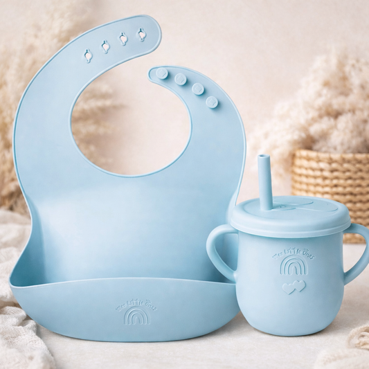 Blue silicone bib and sippy cup set on a neutral background