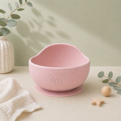 Pink silicone bowl with suction cup on a light surface with decorative elements