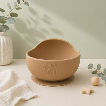 Brown ceramic bowl with a suction cup on a light surface with decorative elements.
