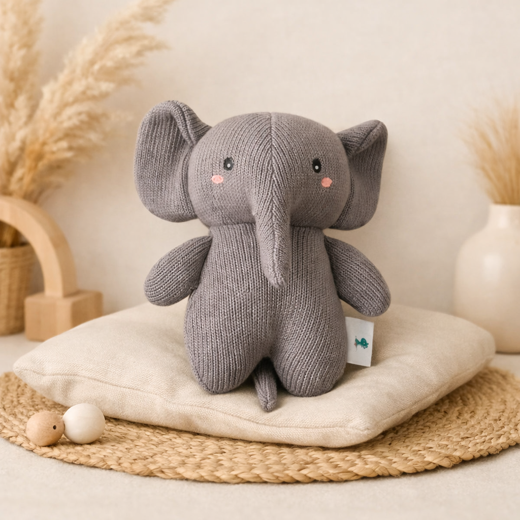 Knitted gray elephant toy with a white background