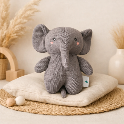 Knitted gray elephant toy with a white background