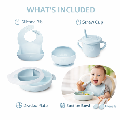Baby feeding set with silicone bib, straw cup, divided plate, suction bowl, and utensils on a white background.