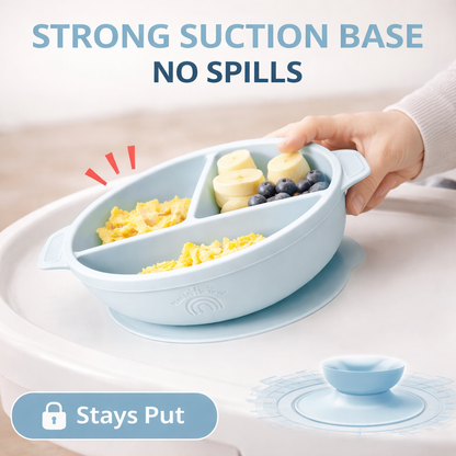 Children's plate with divided sections containing food, held by a hand on a light background.