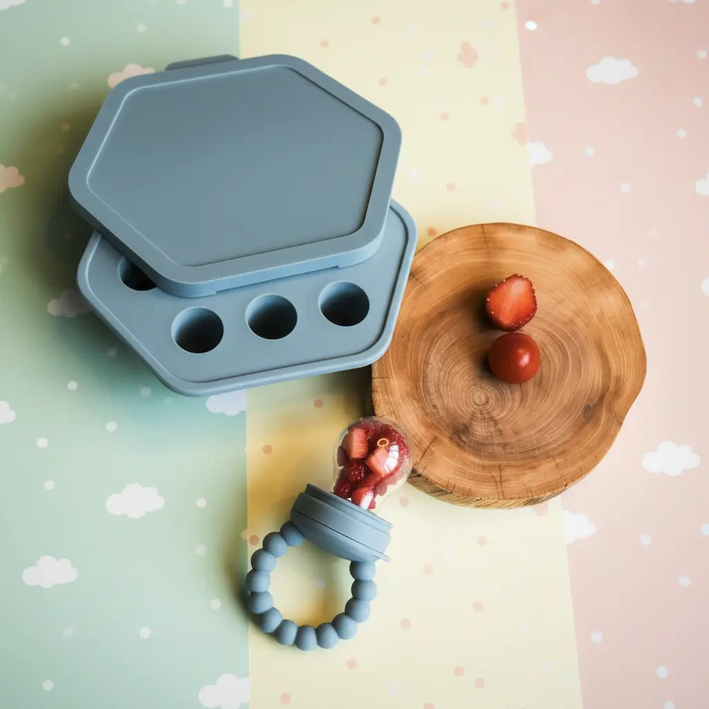 Blue hexagonal silicone fresh food feeder with lid and handle ring.