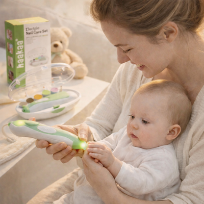 Woman holding a baby and using a green electronic device with a box labeled 'haakaa' in the background.
