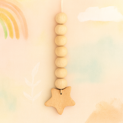 Wooden pacifier clip with round beads and star-shaped charm on beige cord.
