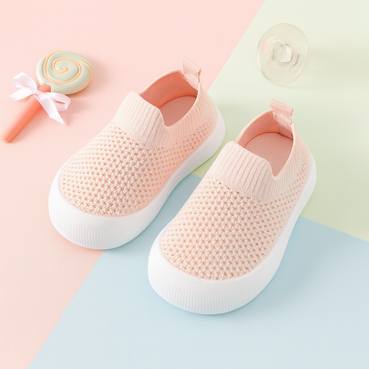 Pink breathable toddler shoes with soft white soles and slip-on design.