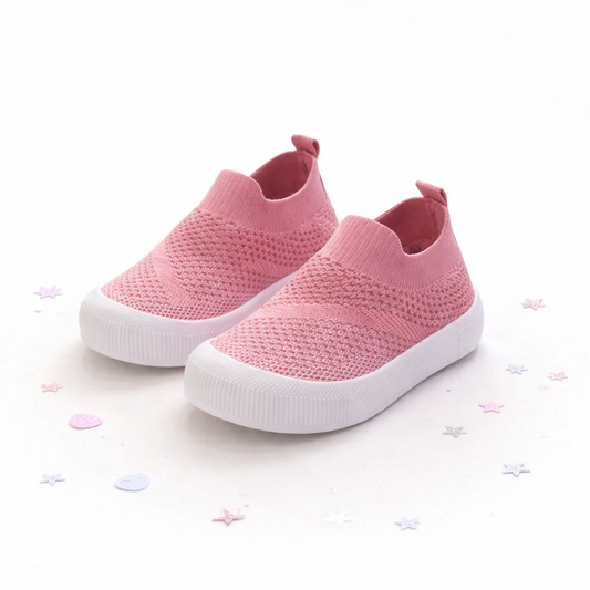 Pink slip-on shoes with white soles on a light background