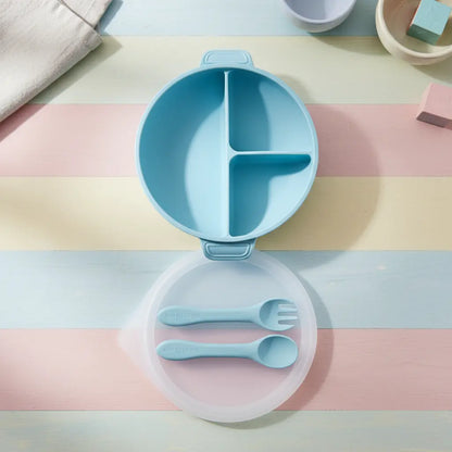Baby blue silicone divided plate with matching fork and spoon on pastel striped background.