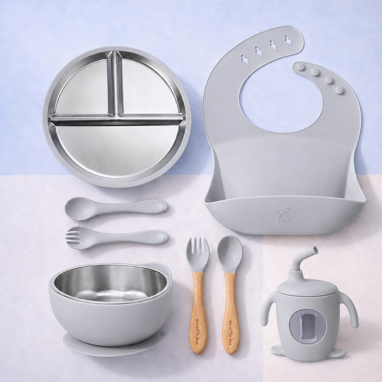 Collection of children's dining utensils and accessories including a plate, bowl, spoon, fork, bib, and cup on a light blue background.