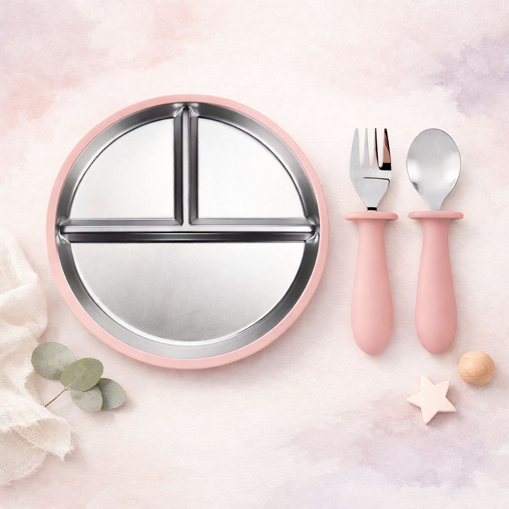 Pink children's plate with compartments, fork, and spoon on a light pink background