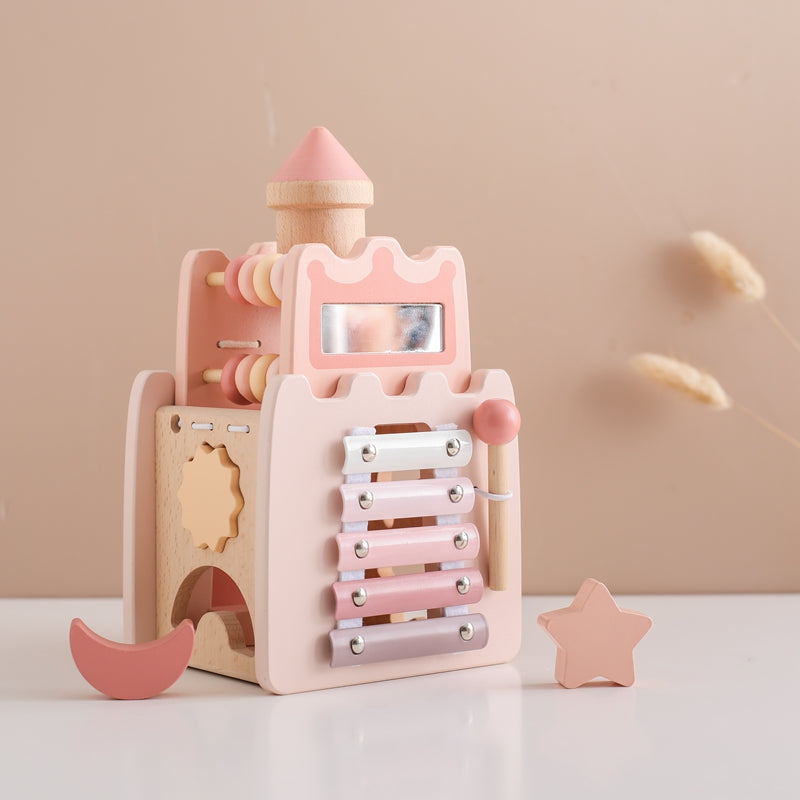 Pink and natural wood Princess Castle toy with xylophone and shape sorter pieces.