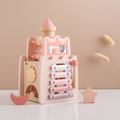 Pink and natural wood Princess Castle toy with xylophone and shape sorter pieces.