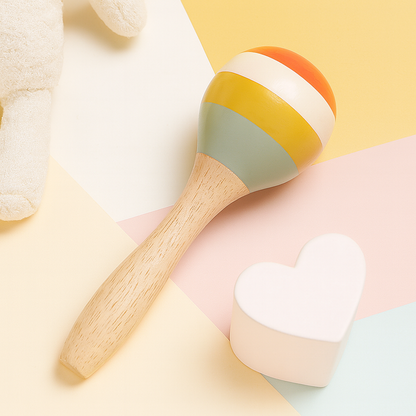 Wooden maraca with orange, white, yellow, and light blue stripes and natural wood handle on pastel background.