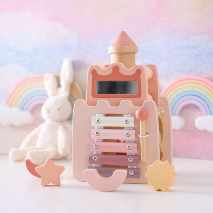 Wooden toy xylophone with pastel colors on a soft background with rainbow and cloud decorations.