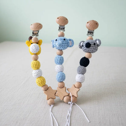 Yellow giraffe, blue elephant, and gray koala, each with round crochet beads and wooden star accents.