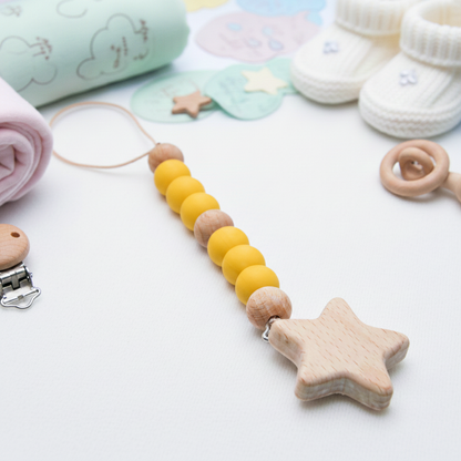 Pacifier clip with yellow and brown wooden beads and a star-shaped wooden teether attached.