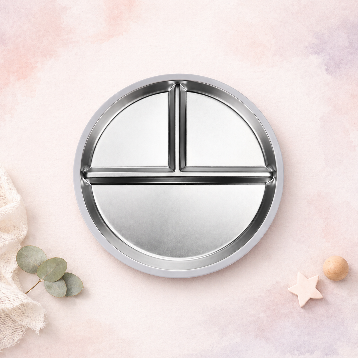 Round metal tray with compartments on a soft pink background