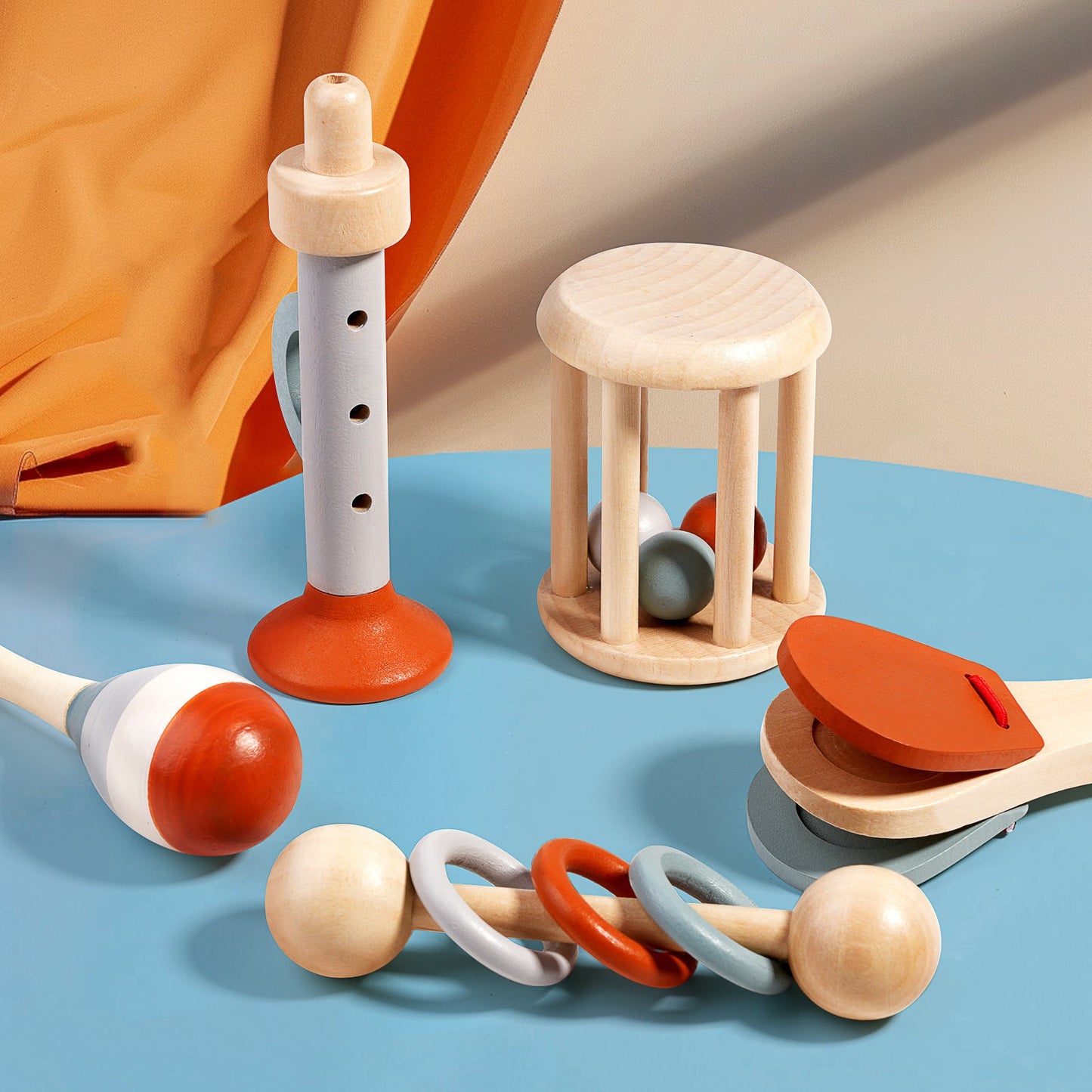 Wooden baby musical toy set with maracas, rattle, and tambourine in natural and orange colors.