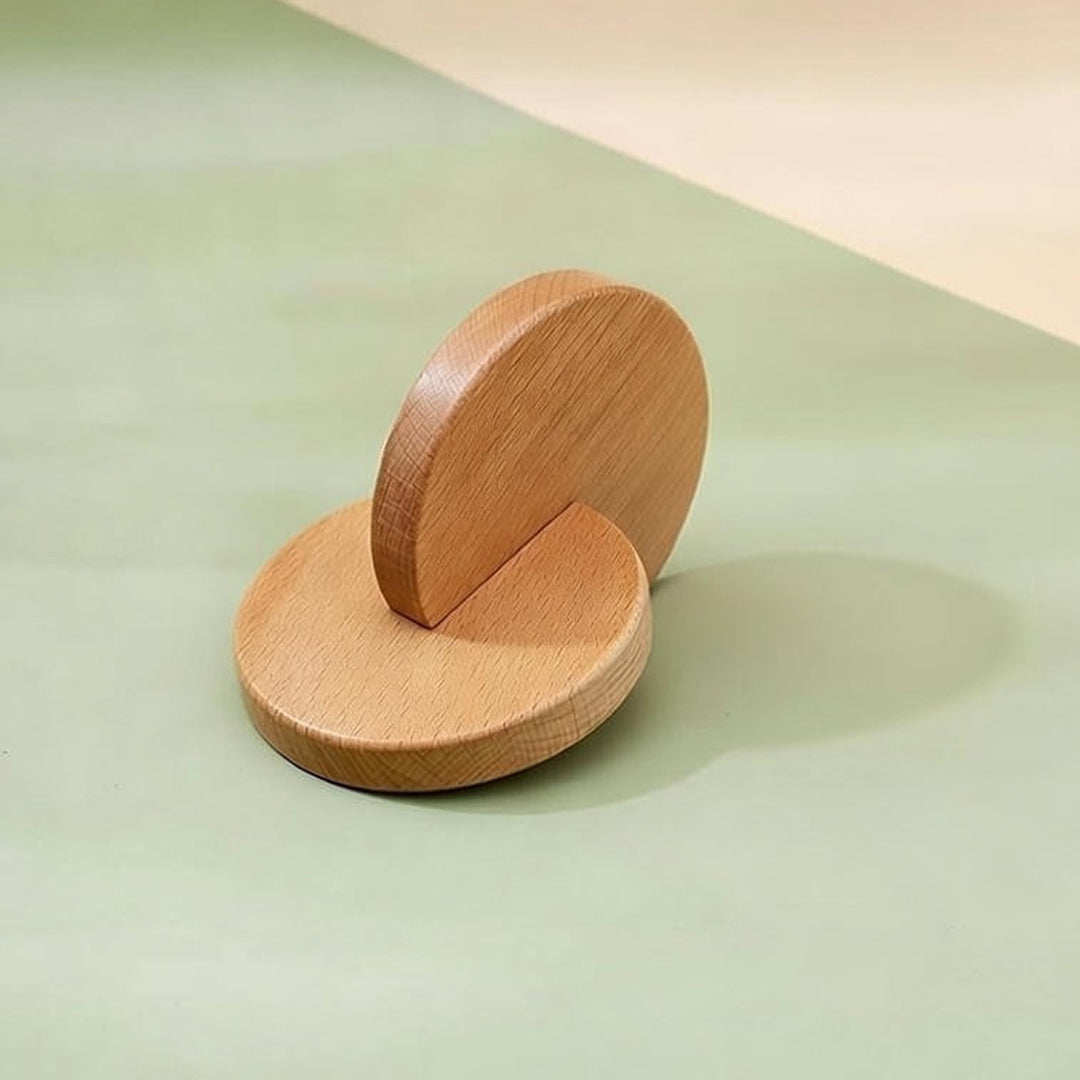 Two wooden circular objects on a light green surface